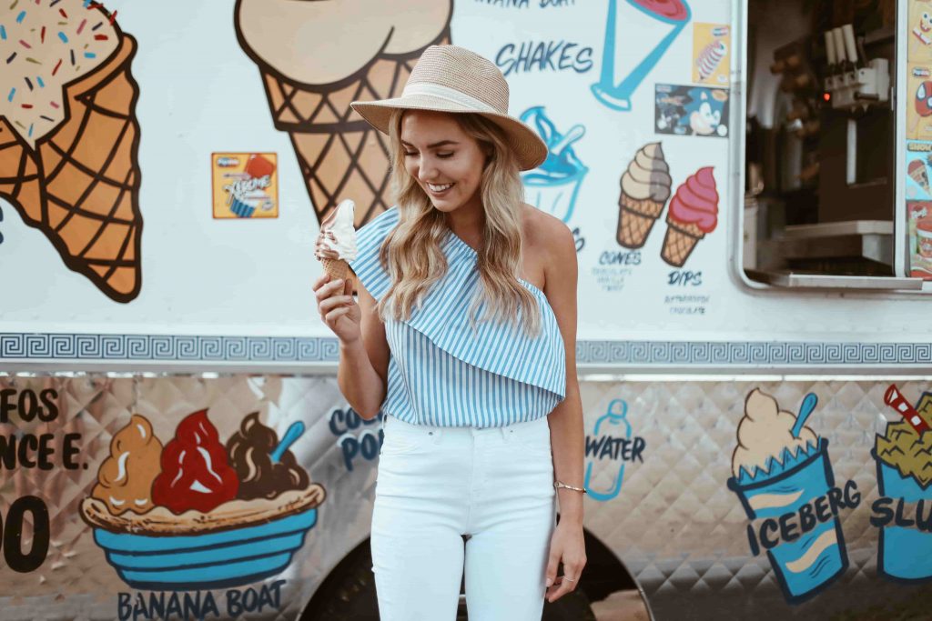 Woman outside an ice cream van eating soft serve ice cream