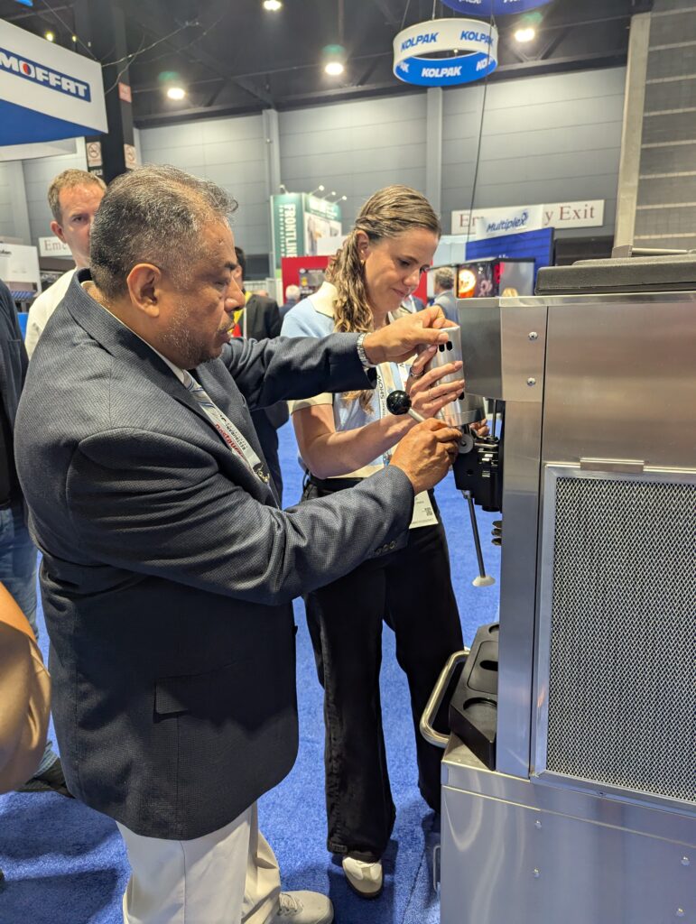 An Electro Freeze team member demonstrates with a customer how easy it is to assemble and disassemble the Shake head.